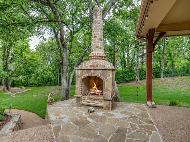 view of patio featuring fence and an outdoor stone fireplace