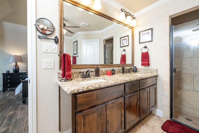 full bathroom with crown molding, a sink, and a stall shower
