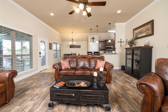 living area featuring ceiling fan with notable chandelier, recessed lighting, baseboards, wood finished floors, and ornamental molding