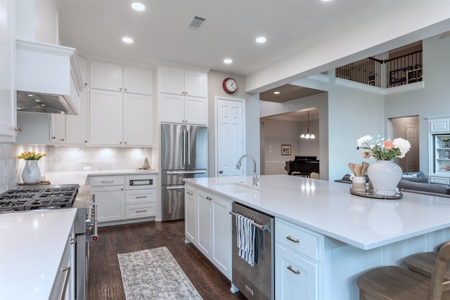 kitchen with recessed lighting, a sink, high end appliances, and white cabinets