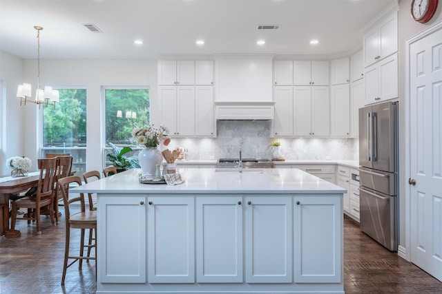 kitchen with white cabinets, dark wood-style flooring, an inviting chandelier, light countertops, and high quality fridge