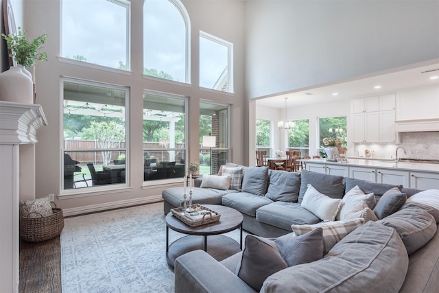 living area featuring recessed lighting, a high ceiling, and a chandelier