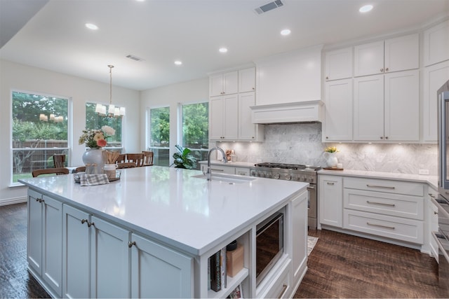 kitchen featuring white cabinets, stainless steel appliances, visible vents, and a sink