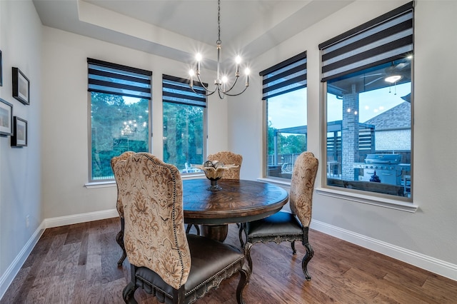 dining area featuring baseboards, dark wood finished floors, and a notable chandelier