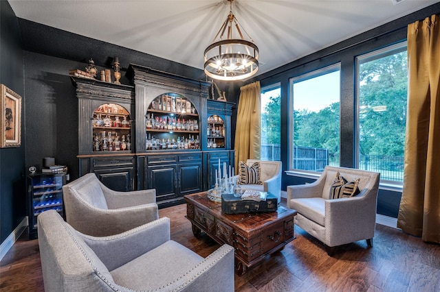 sitting room with an inviting chandelier, baseboards, and wood finished floors