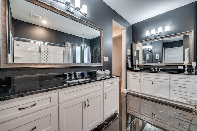 full bathroom with a sink, two vanities, a stall shower, and visible vents