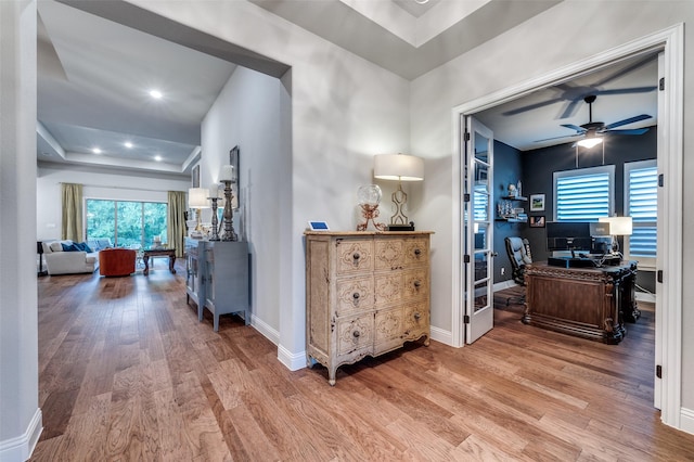 hallway with baseboards, a healthy amount of sunlight, and wood finished floors