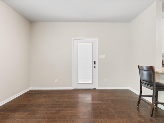 unfurnished room featuring baseboards and wood finished floors