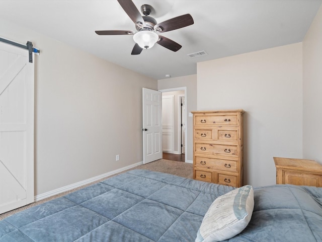 bedroom featuring baseboards, a ceiling fan, a barn door, and visible vents