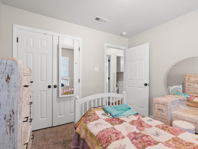 carpeted bedroom featuring visible vents and a closet