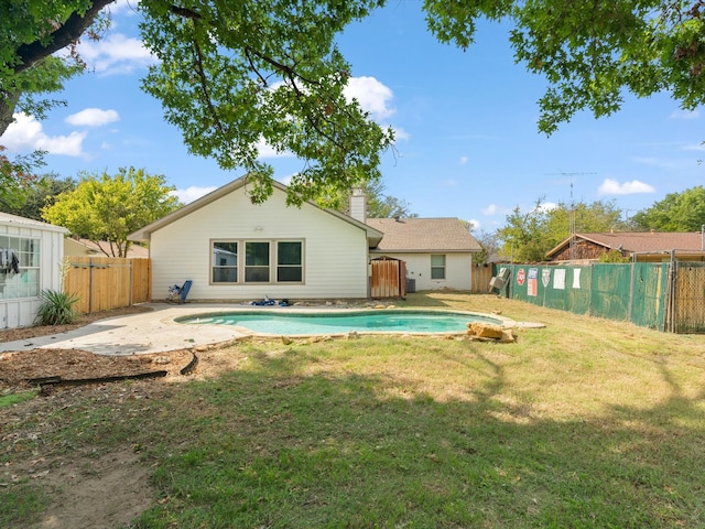 back of house with a yard, a fenced in pool, a chimney, and a fenced backyard