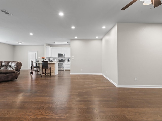 living area featuring baseboards, a ceiling fan, visible vents, and recessed lighting