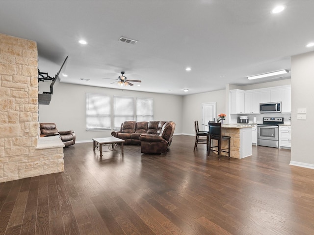 living room with baseboards, visible vents, and dark wood-style floors