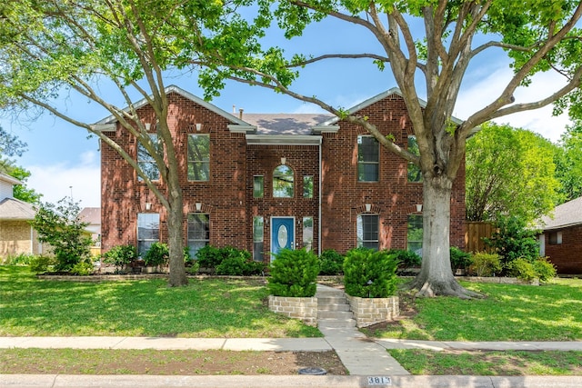 view of front of property featuring a front yard and brick siding