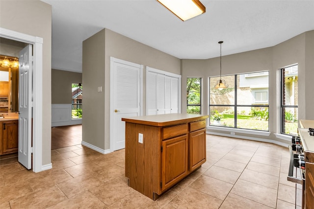 3813 Parkmont Dr, Plano, TX 75023 - kitchen with pendant lighting, a kitchen island, light countertops, and plenty of natural light