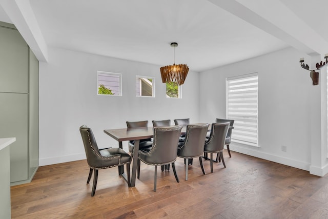 dining space featuring baseboards, a chandelier, and wood finished floors