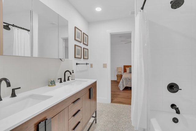 bathroom with double vanity, recessed lighting, a sink, and shower / tub combo
