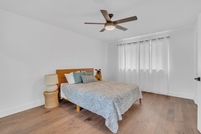 bedroom featuring baseboards, ceiling fan, and wood finished floors