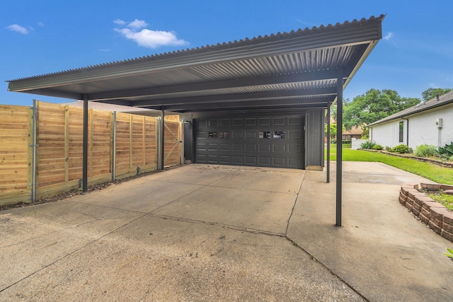 view of vehicle parking featuring a detached garage and fence