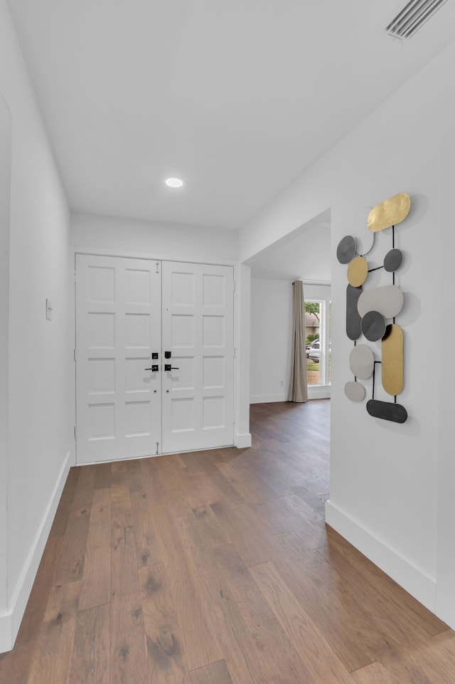 entryway with visible vents, baseboards, and wood finished floors