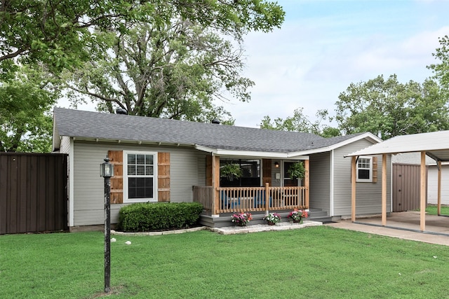 ranch-style home featuring fence, a carport, a porch, and a front lawn