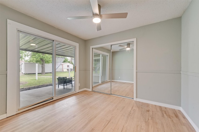 unfurnished bedroom featuring access to outside, baseboards, wood finished floors, and a closet