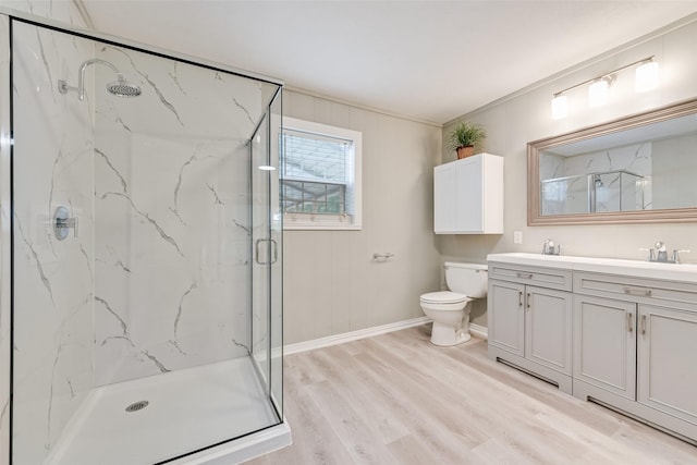 full bath with double vanity, wood finished floors, toilet, baseboards, and a marble finish shower