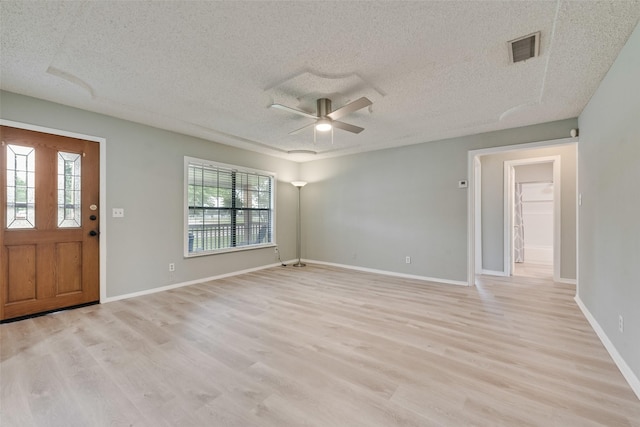 entryway with ceiling fan, light wood-style flooring, a textured ceiling, and visible vents