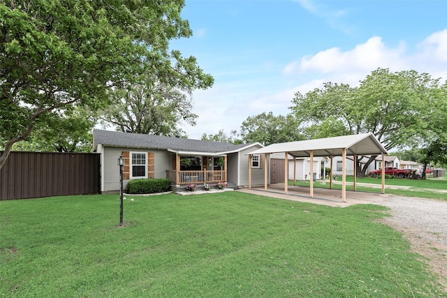 view of front of property featuring covered porch, a front lawn, a detached carport, and dirt driveway