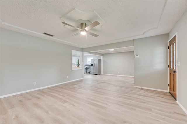 spare room with visible vents, a ceiling fan, a textured ceiling, and light wood-type flooring