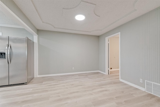 interior space featuring visible vents, baseboards, a textured ceiling, and wood finished floors