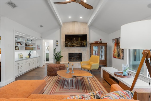 living room with a ceiling fan, visible vents, a large fireplace, wood finished floors, and lofted ceiling with beams