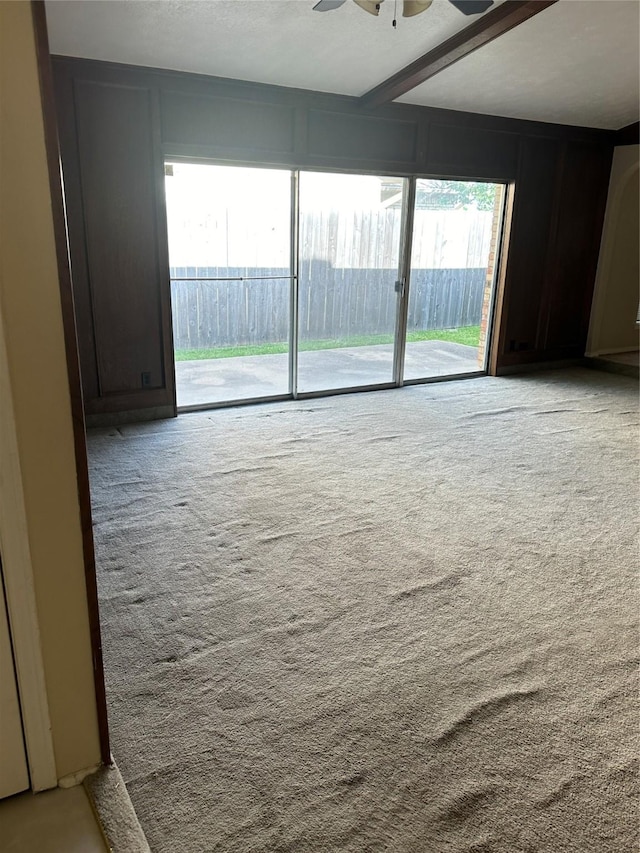 unfurnished room with carpet floors, a ceiling fan, and a wealth of natural light
