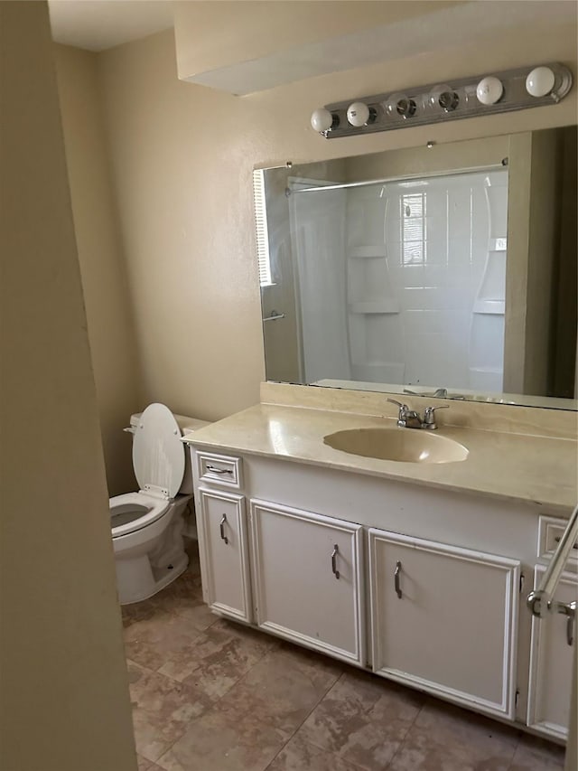 bathroom featuring vanity, walk in shower, and toilet
