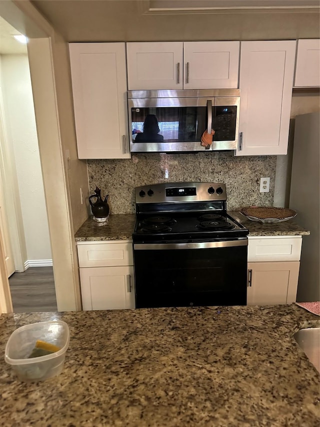 kitchen with stainless steel appliances, white cabinetry, and tasteful backsplash