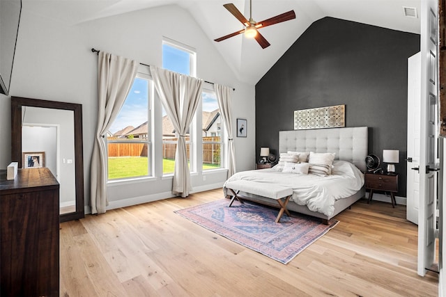 bedroom with visible vents, baseboards, ceiling fan, high vaulted ceiling, and light wood finished floors