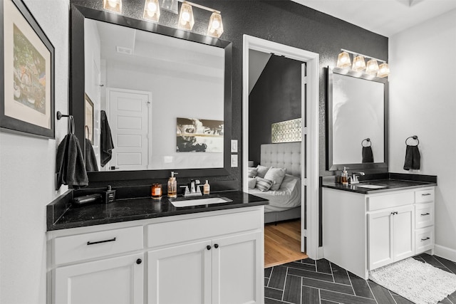 full bathroom featuring a sink, ensuite bathroom, and two vanities