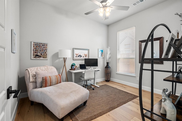 home office featuring visible vents, baseboards, ceiling fan, and wood finished floors