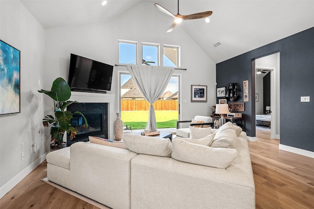 living room with baseboards, a ceiling fan, high vaulted ceiling, and wood finished floors