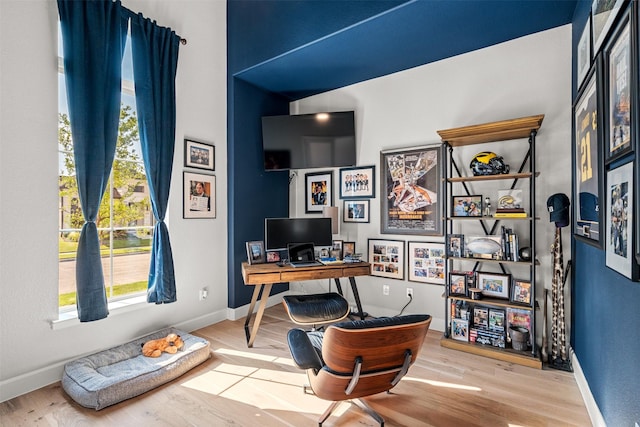 office area with baseboards, a healthy amount of sunlight, and wood finished floors