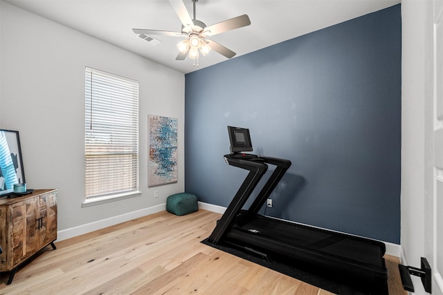 exercise room with baseboards, a ceiling fan, wood finished floors, and a healthy amount of sunlight
