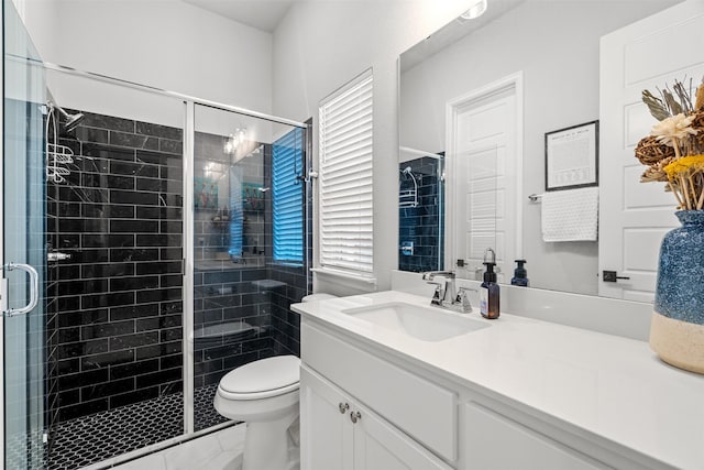 bathroom featuring vanity, a stall shower, and toilet