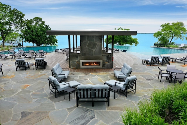 view of patio featuring a community pool, an outdoor living space, and a deck with water view