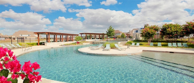 community pool with a pergola, fence, and a patio area