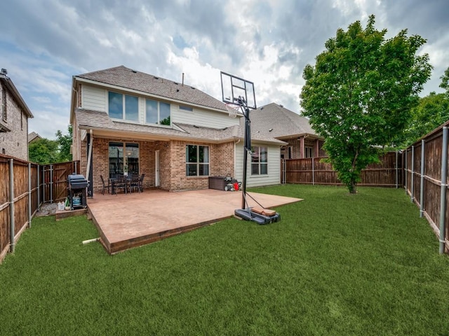 rear view of house with a lawn, a patio, brick siding, and a fenced backyard