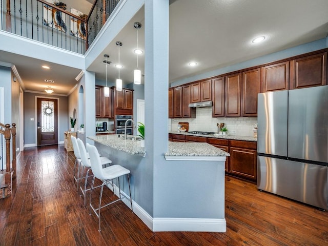 kitchen with ornamental molding, baseboards, tasteful backsplash, dark wood finished floors, and appliances with stainless steel finishes