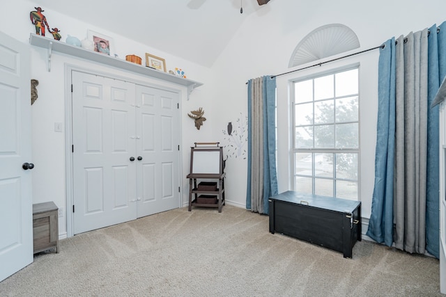 entrance foyer featuring a ceiling fan, light carpet, and lofted ceiling