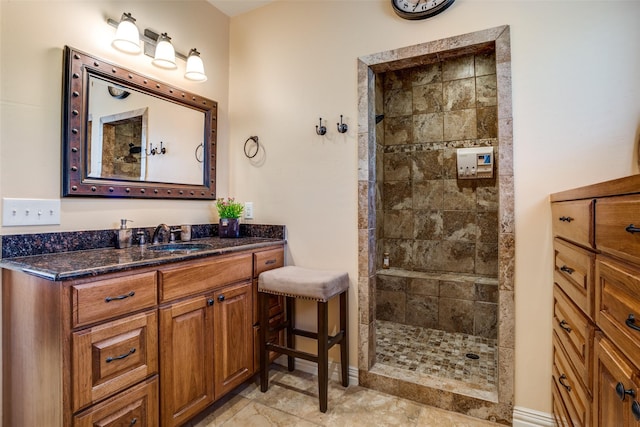 full bath with a tile shower and vanity