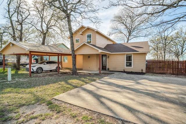 view of front of house featuring a front lawn, fence, and an attached carport