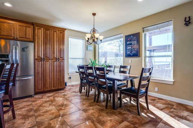 dining space with dark tile patterned flooring, recessed lighting, baseboards, and a chandelier